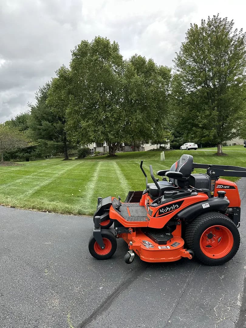 Keystone zero-turn mower parked on a freshly mowed lawn with tree line in background.