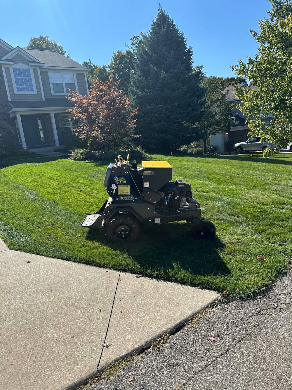 Lawn care equipment on a residential lawn, showcasing neat grass and landscaping.